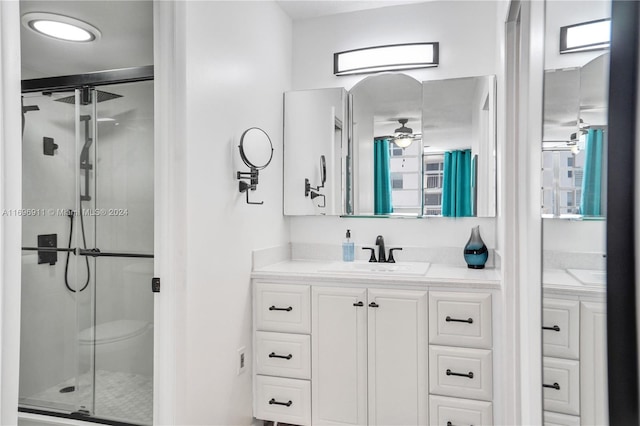 bathroom with ceiling fan, vanity, and a shower with shower door