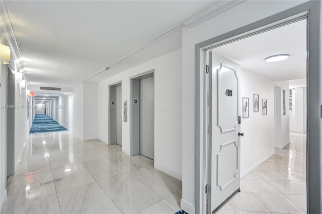 hall featuring elevator and a textured ceiling