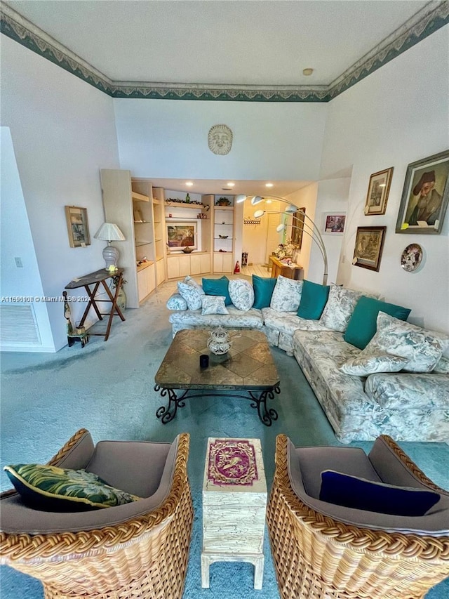 carpeted living room featuring a textured ceiling, built in features, and ornamental molding