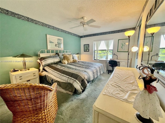 carpeted bedroom featuring ceiling fan and a textured ceiling