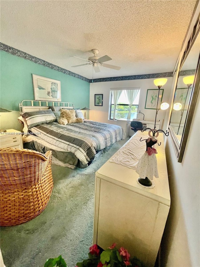 carpeted bedroom with ceiling fan and a textured ceiling