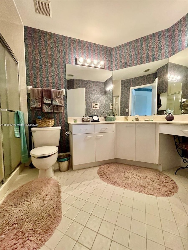 bathroom with toilet, tile patterned flooring, vanity, and walk in shower