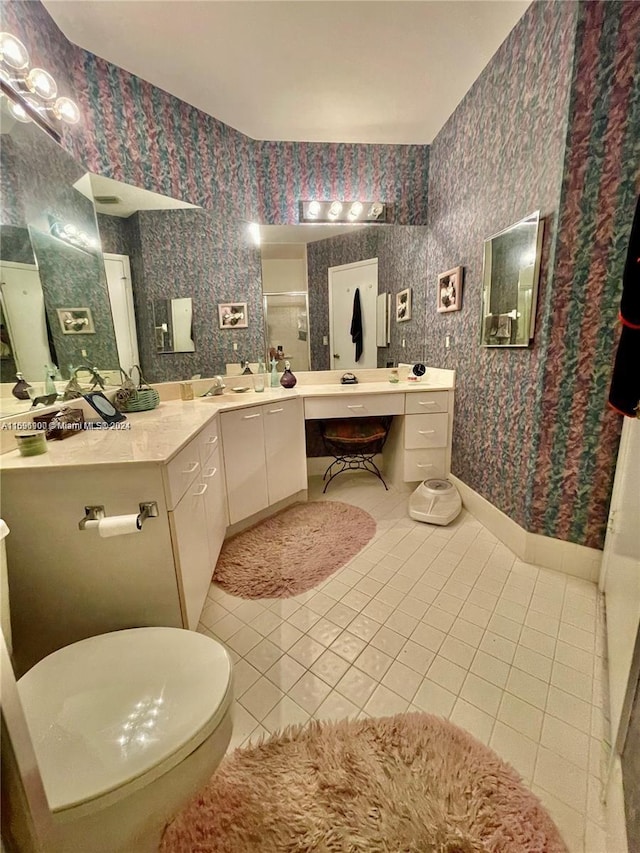 bathroom featuring tile patterned flooring, vanity, toilet, and an enclosed shower