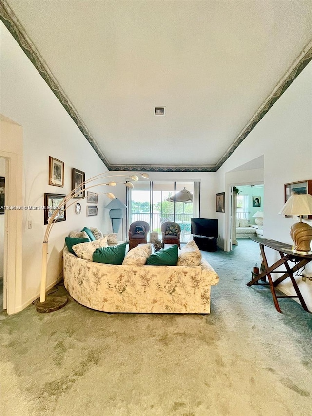 living room featuring a textured ceiling, ornamental molding, carpet floors, and vaulted ceiling