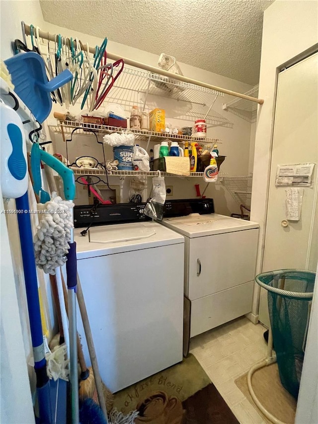 washroom with washing machine and dryer and a textured ceiling