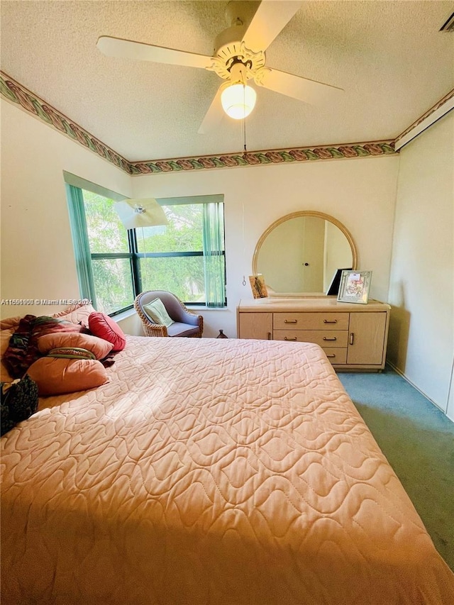 carpeted bedroom with ceiling fan and a textured ceiling