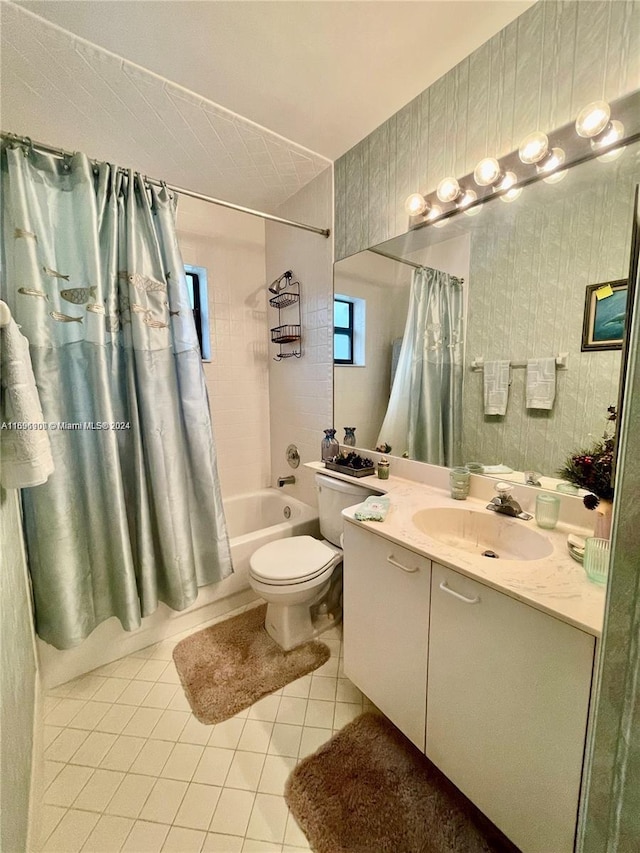 full bathroom featuring tile patterned floors, shower / bath combo with shower curtain, vanity, and toilet