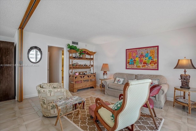 living room featuring light tile patterned floors and a textured ceiling