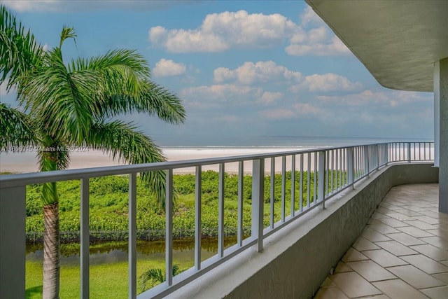 balcony featuring a water view and a view of the beach