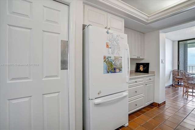 kitchen featuring white cabinetry, tile patterned flooring, and white refrigerator