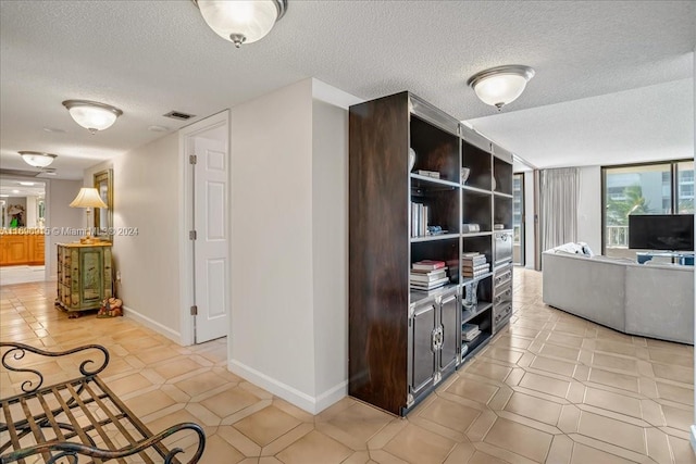 interior space featuring light tile patterned flooring and a textured ceiling