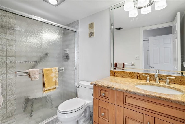 bathroom with a shower with door, vanity, and toilet