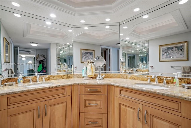 bathroom with vanity, a raised ceiling, and ornamental molding