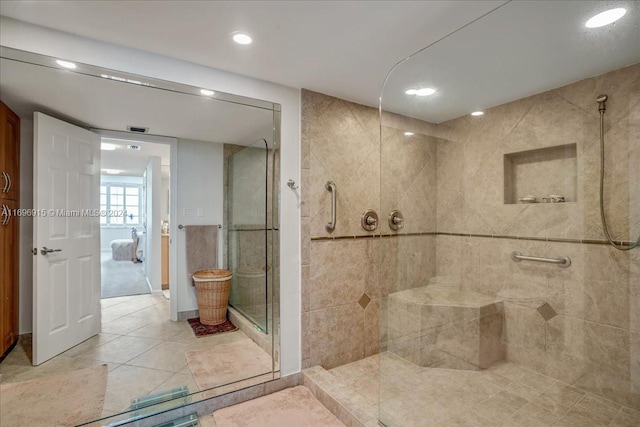 bathroom featuring tile patterned flooring and a tile shower