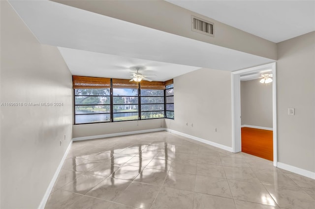 tiled empty room featuring ceiling fan