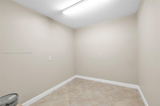 unfurnished room featuring a textured ceiling