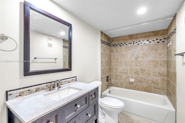 full bathroom featuring tiled shower / bath combo, toilet, and vanity