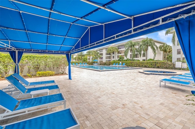 view of pool featuring a jacuzzi and a patio