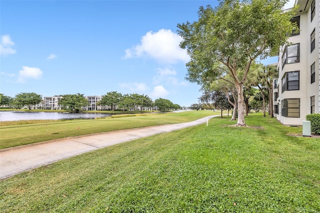 view of home's community with a lawn and a water view