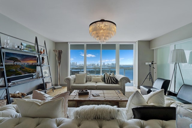 living room with a chandelier, a water view, and floor to ceiling windows