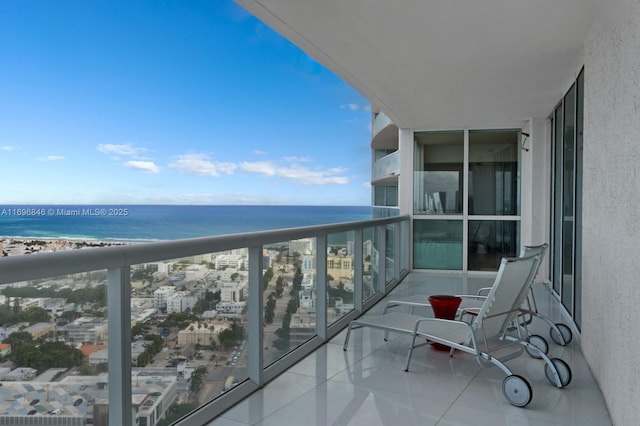 balcony with a water view and a view of the beach