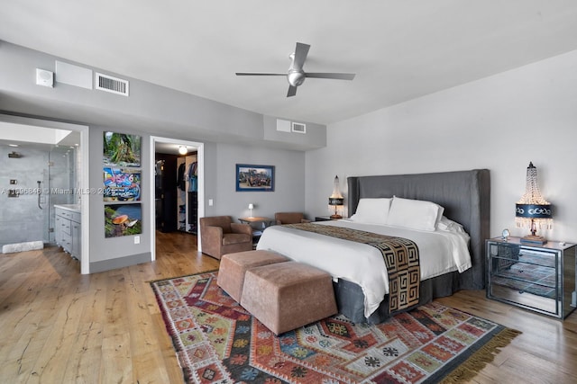 bedroom featuring light wood-type flooring, ceiling fan, a spacious closet, connected bathroom, and a closet