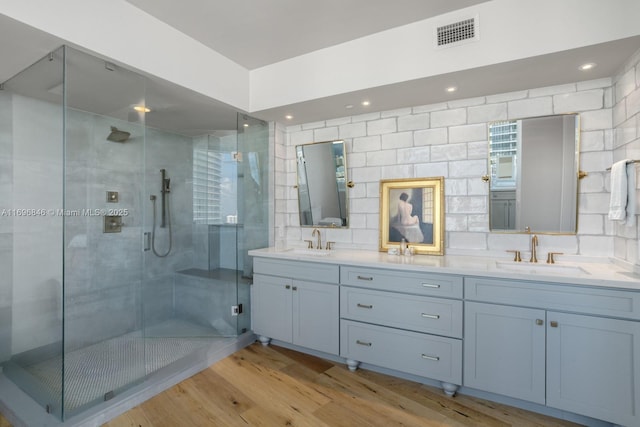 bathroom featuring hardwood / wood-style floors, vanity, and walk in shower