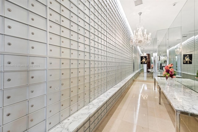 hallway with a mail area and an inviting chandelier