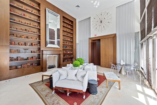 living area featuring built in shelves and wooden walls