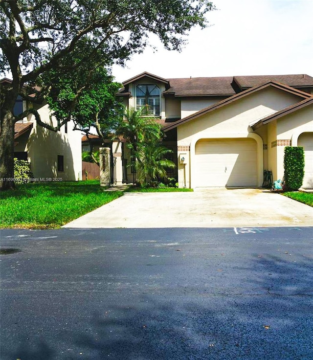 view of front of property featuring a garage, roof with shingles, stucco siding, and driveway