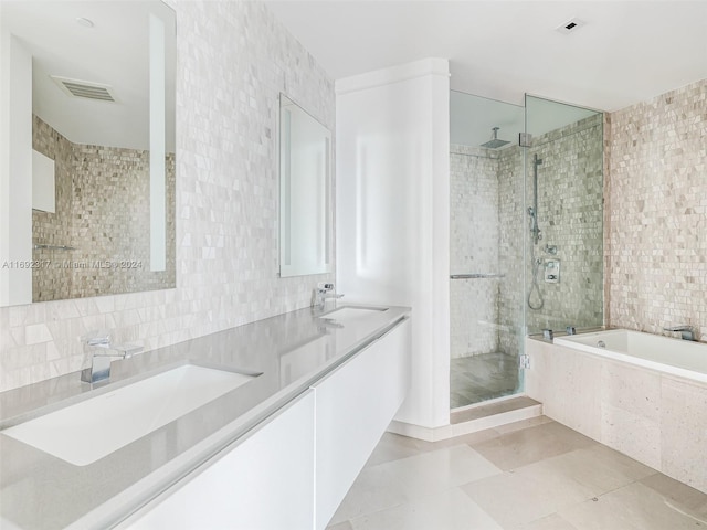 bathroom featuring tasteful backsplash, tile patterned flooring, plus walk in shower, and tile walls