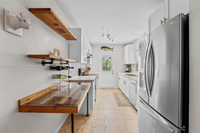 kitchen featuring white cabinets, light tile patterned floors, and appliances with stainless steel finishes