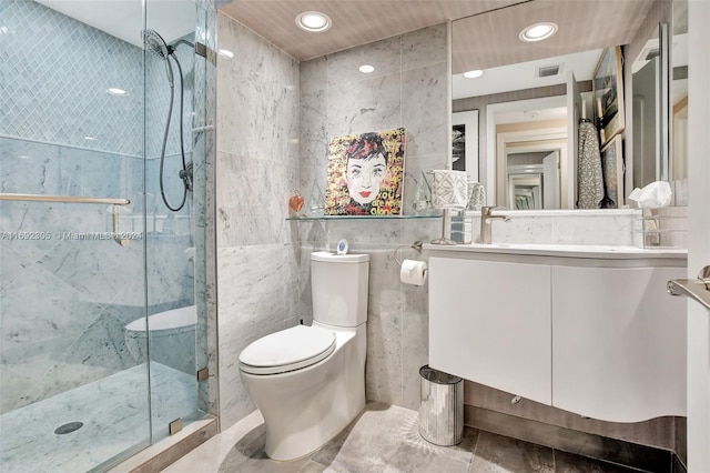 bathroom featuring vanity, a shower with door, toilet, and tile walls