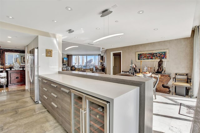 kitchen with pendant lighting, stainless steel fridge, light hardwood / wood-style floors, and beverage cooler