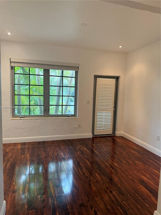 empty room with dark hardwood / wood-style flooring