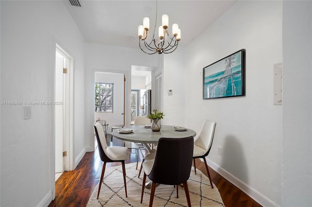 dining area with a notable chandelier, baseboards, and wood finished floors