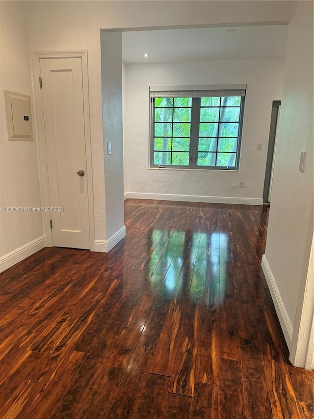 unfurnished room featuring electric panel and dark hardwood / wood-style floors