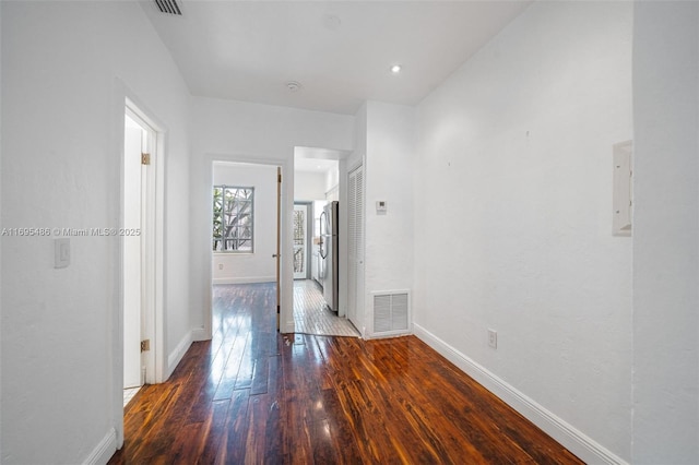 interior space featuring baseboards, visible vents, and dark wood-type flooring