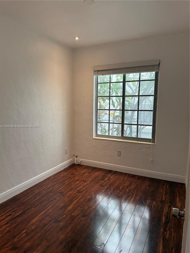 empty room with dark hardwood / wood-style flooring