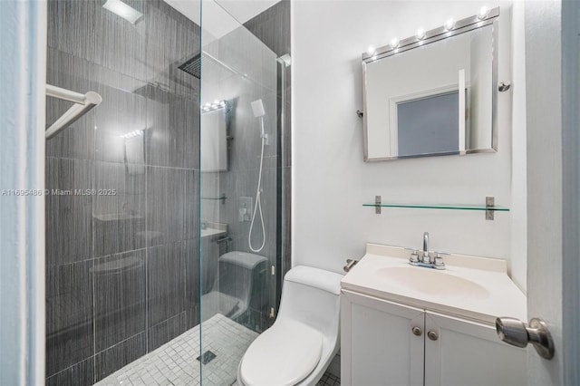 full bathroom with tiled shower, vanity, and toilet