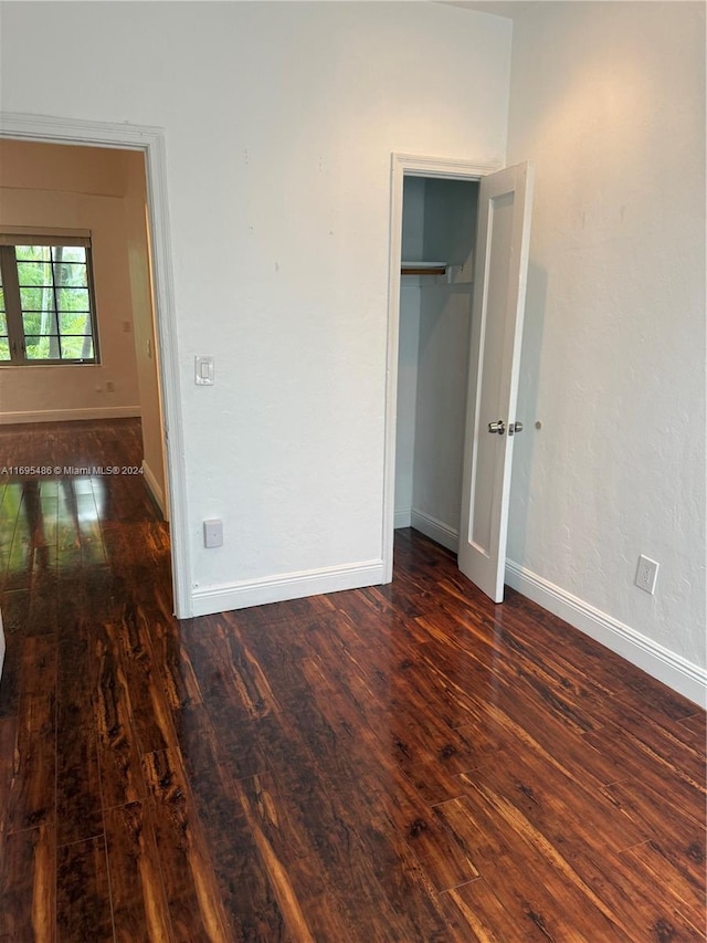 unfurnished bedroom with dark hardwood / wood-style floors