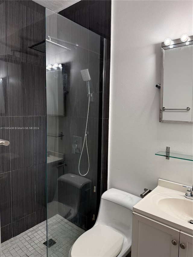 bathroom featuring vanity, toilet, and a shower with shower door