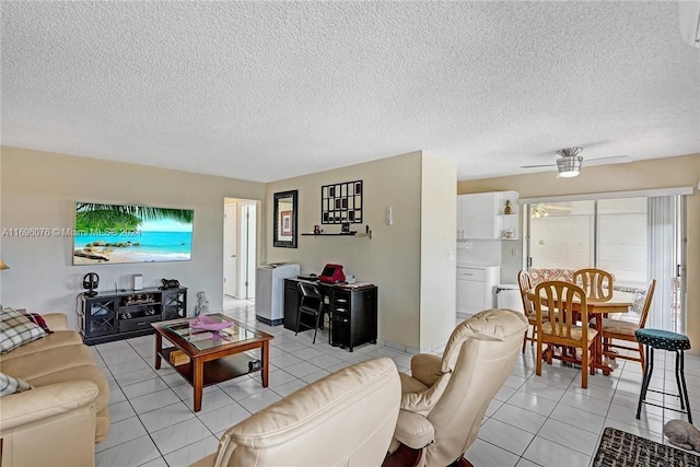 living room featuring ceiling fan, light tile patterned floors, and a textured ceiling