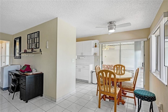 tiled dining space with a textured ceiling and ceiling fan