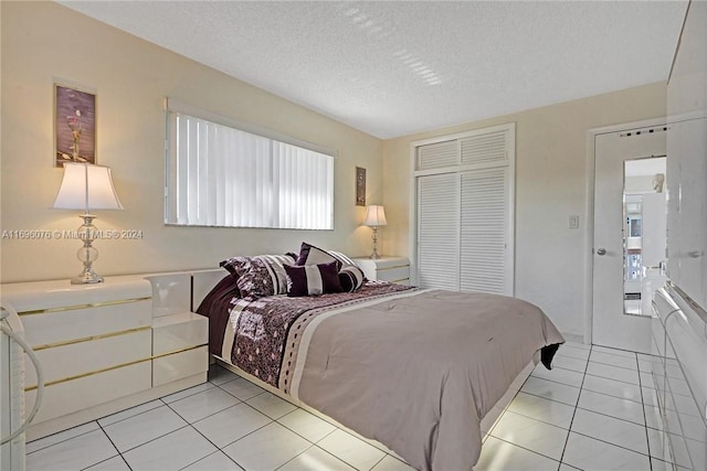 tiled bedroom featuring multiple windows, a textured ceiling, and a closet