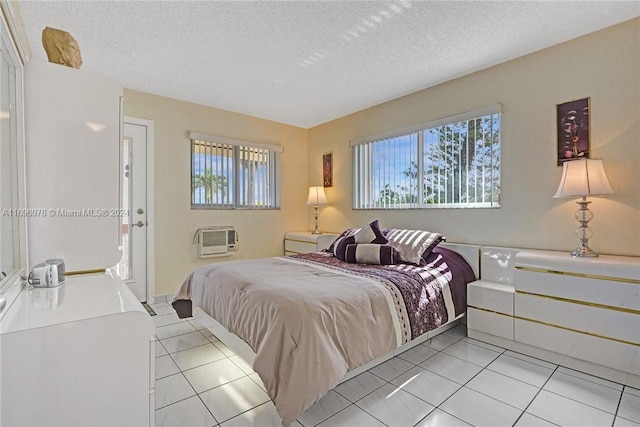 1015 SW 11th Ave Unit 11K, Hallandale Beach, FL 33009 - bedroom featuring multiple windows, light tile patterned flooring, a textured ceiling, and an AC wall unit