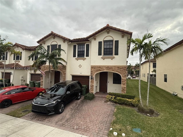 mediterranean / spanish-style house with a garage and a front lawn