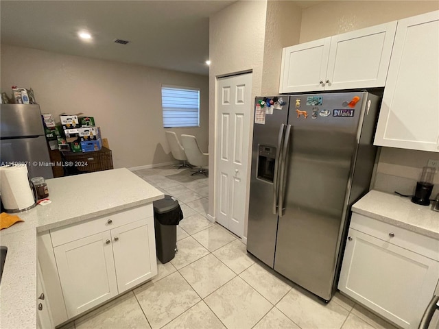 kitchen featuring white cabinets, stainless steel fridge, light tile patterned floors, and stainless steel refrigerator