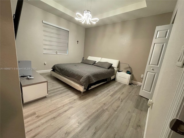 bedroom featuring a notable chandelier and light wood-type flooring