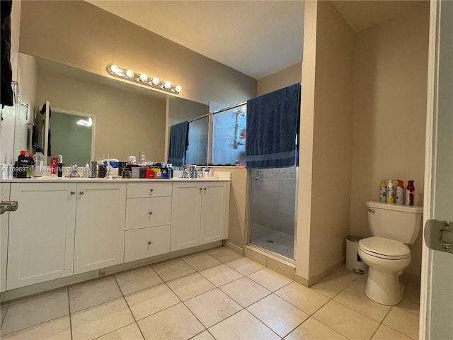 bathroom featuring tile patterned flooring, vanity, toilet, and a shower with shower door